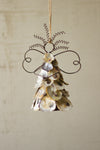 Decorative angel ornament made of seashells on a beige background