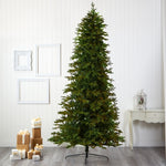 Tall artificial Christmas tree in a room with decorative items on the floor.