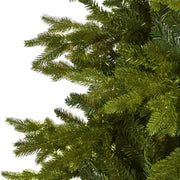 Close-up of a green artificial Christmas tree branch on a white background