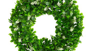Green leafy wreath with small white flowers on a white background