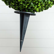 Black wall-mounted plant holder with a green potted plant on a white wall background