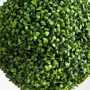 Close-up of a spherical artificial green bush on a white background