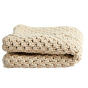 Folded beige blanket on a white background