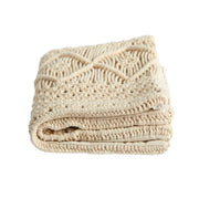 Folded beige knitted blanket on a white background