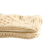 Folded beige textured blanket on a white background