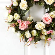 Floral wreath with pink and white flowers on a white door