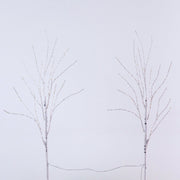 Two bare artificial tree branches with thin wire strands, set against a plain light gray background.