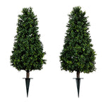 Two artificial trees with stakes on a white background