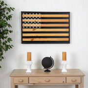 Wooden table with decor items and a wooden American flag wall art piece.
