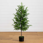 Potted artificial Christmas tree on a wooden floor with a white wall background