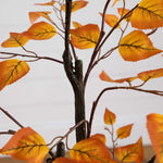 Artificial autumn leaf branch with orange leaves on a white background