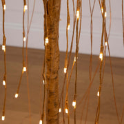 Decorative string lights hanging from branches against a neutral background