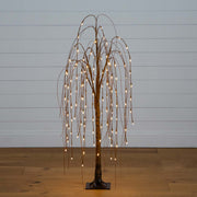 Decorative tree with lights against a plain wall