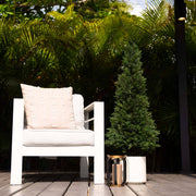 White chair with a beige pillow on a wooden deck surrounded by greenery