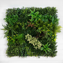 A square artificial living green wall made of dense faux foliage and assorted plants, mounted against a white wood plank background.