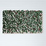 A rectangular artificial greenery wall panel featuring dense green faux leaves, pink faux flowers, and a brown lattice trellis frame, displayed against a white background with horizontal lines.