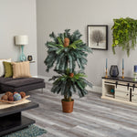 Living room with a large decorative plant, gray sofa, and wooden coffee table.