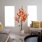 Decorative indoor tree with autumn leaves in a living room setting.