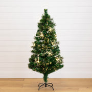 A pre-lit artificial Christmas tree with green needles and warm white lights, standing on a black metal stand against a white shiplap wall and light wood floor.