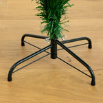 A black metal Christmas tree stand with five legs, shown holding the green trunk of a artificial Christmas tree on a light brown wooden floor.