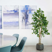 Modern interior with abstract art, a plant, and a table with chairs.