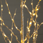 Warm white LED branch lights wrapped around a white decorative tree trunk, with glowing lights on twisting wire branches against a dark gray background.