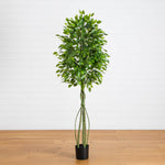 Artificial potted plant with green leaves on a wooden floor against a white wall
