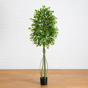 Artificial potted plant with green leaves on a wooden floor against a white wall