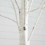 A close-up of a white birch-style tree branch structure, likely a decorative artificial tree or tree trunk display, with thin branches extending outward against a pale gray background.