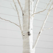 A close-up of a white birch-style tree branch structure, likely a decorative artificial tree or tree trunk display, with thin branches extending outward against a pale gray background.