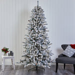 Frosted Christmas tree in a room with a chair and small table.