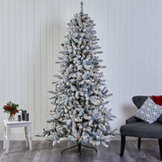 Frosted Christmas tree in a room with a chair and small table.