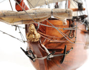 Close-up of a model ship with a figurehead on a white background